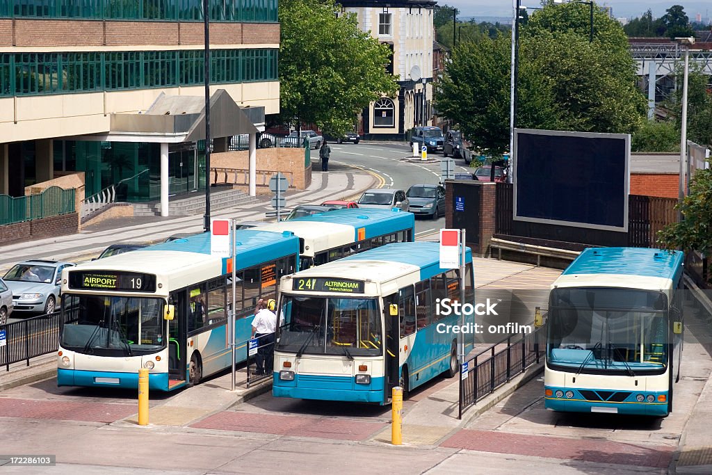Blue buses waiting at a station in a small city "Bus station in Altrincham, Cheshire, UK." Bus Stock Photo