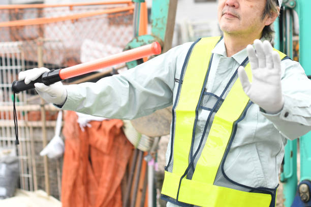 istock A middle-aged Asian male worker uses a guide rod to direct traffic at a construction site. 1722866976