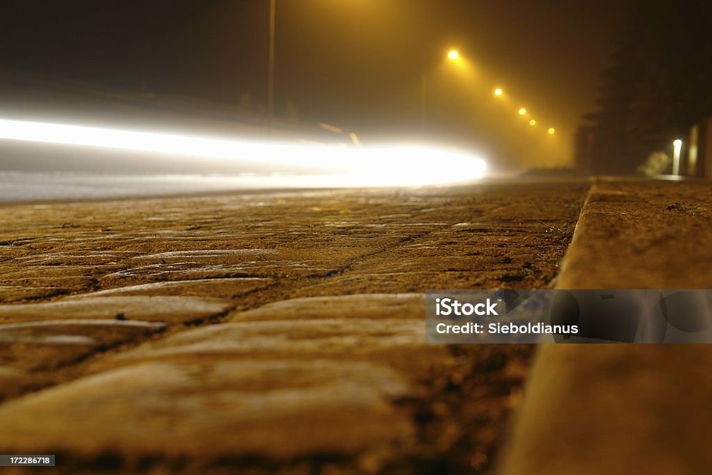Foggy street at night with car driving by. A foggy street at night with a car driving by. Strange. Fear Stock Photo