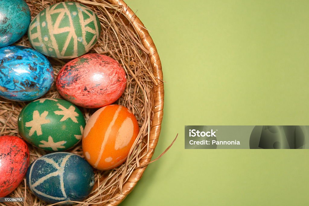 Easter Eggs in Nest on Green Painted easter eggs in basket on green background Easter Basket Stock Photo