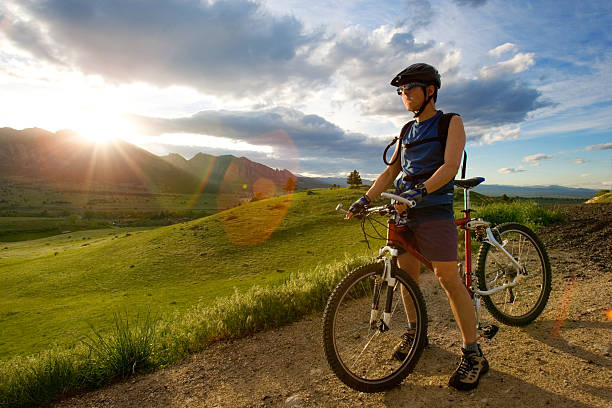 A man standing in a dirt road with a bike stock photo