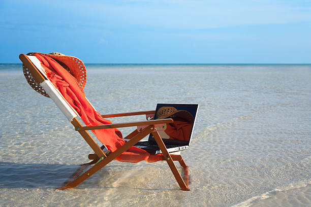 ビーチチェアおよびノートパソコン - outdoor chair beach chair sarong ストックフォトと画像