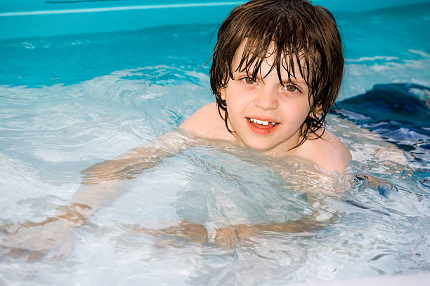 Little Boy Swimming in a Pool Cooling off in a small pool. mm1 stock pictures, royalty-free photos & images
