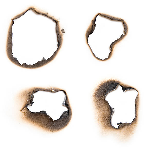 istock Four burn holes on a paper in white 172288683