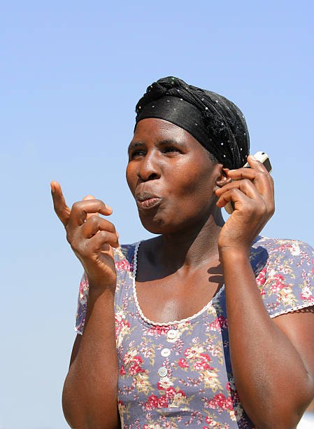 An African lady conveying a message to somebody whilst on her cellphone.