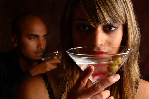 Young couple have martinis in a moody atmosphere.