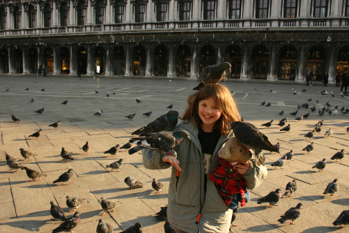 Girl with pigeons in San Marco Square in Venice