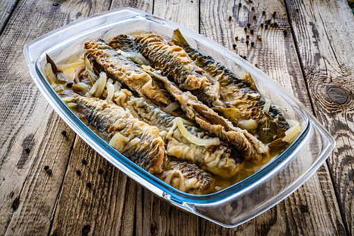 Pickled in vinegar fried herrings on wooden table