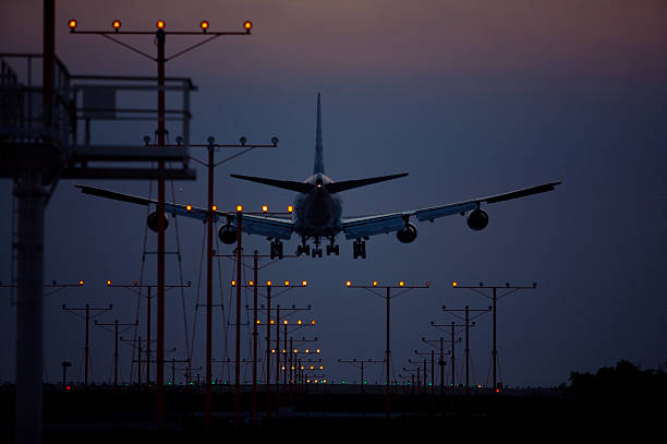 avión aterrizando al atardecer - runway airplane landing landing light fotografías e imágenes de stock