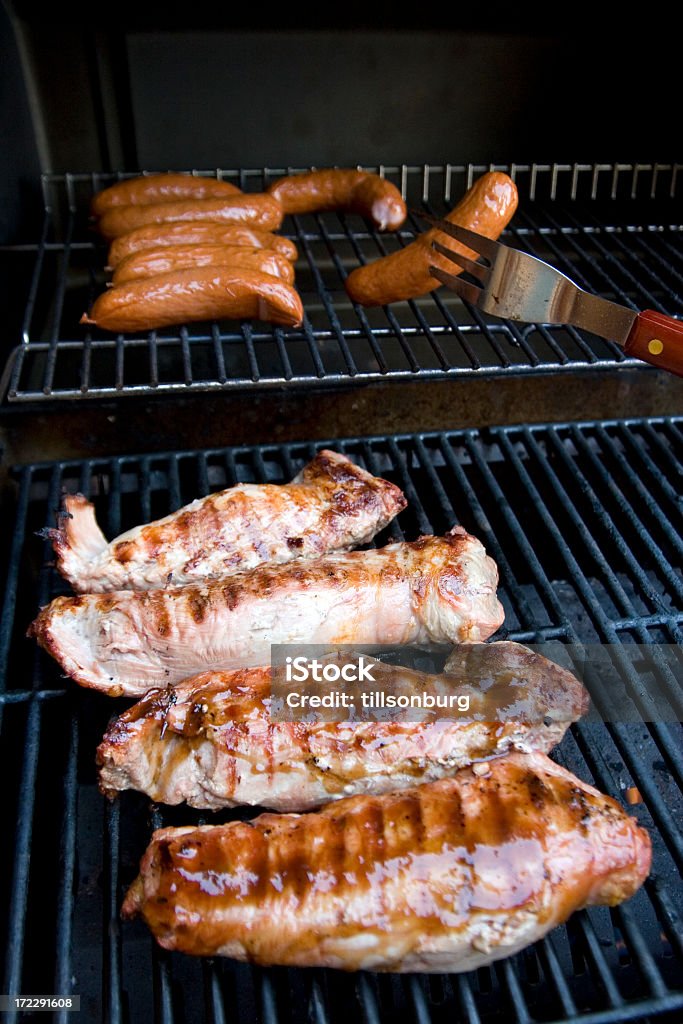 Pork On Fork Pork sausages and tenderloin on barbeque. Barbecue - Meal Stock Photo