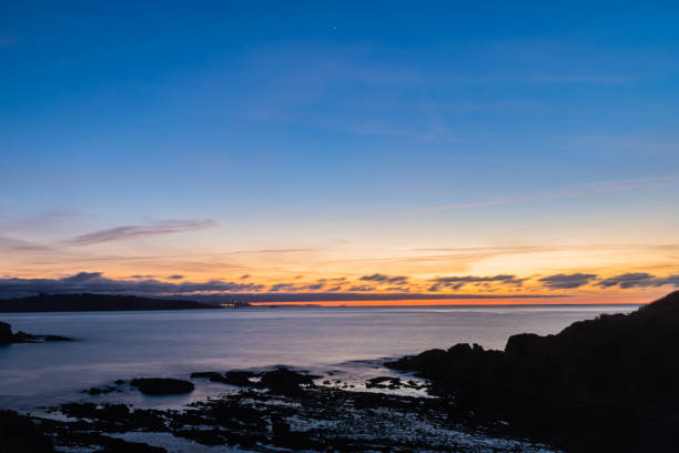 Sunset in the blue hour with long exposure with the cliffs in front. In the photograph you can see a sunset in the blue hour with long exposure with the cliffs in front. sun exposure stock pictures, royalty-free photos & images