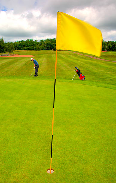 Chipping the Green A golfer prepares to chip onto the green pole photos stock pictures, royalty-free photos & images
