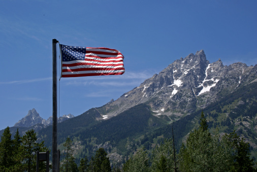 The American flag unfurled with the Teton Mountains in the background.