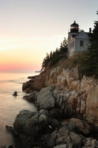 istock Bass Harbor Lighthouse on steep cliff with red horizon 172294731