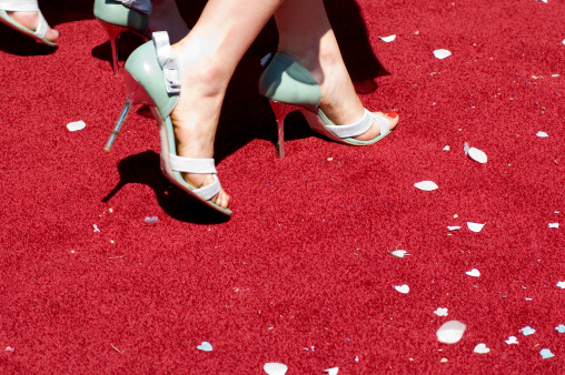 Woman walking on red carpet with confetti