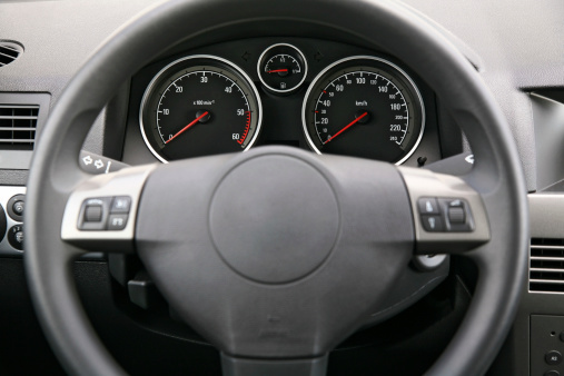 Close-up of a car dashboard, focus is on the meters