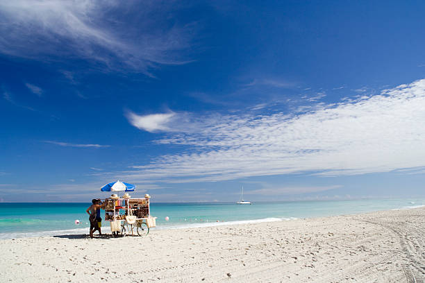 White sandy beach with a merchants cart and umbrella