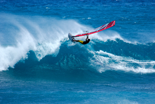 Man on a water sailing windsurfing board. Water sports activity and leasure time