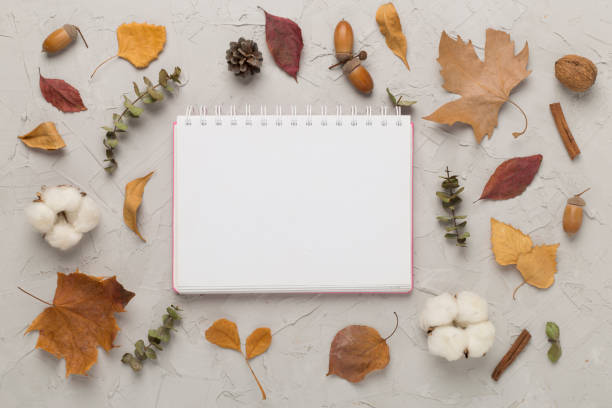istock Autumn leaves with notebook on concrete background, top view 1722961664