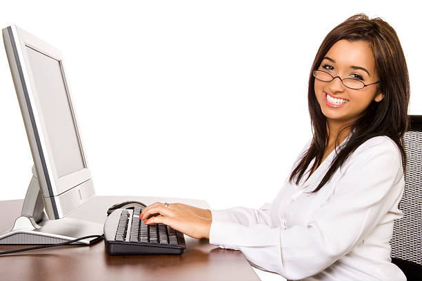 Businesswoman Happily Working Photo of an attractive young businesswoman sitting at her desk with a big smile. francesca01 stock pictures, royalty-free photos & images