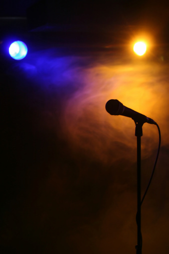 Silhouette of a microphone under yellow and blue reflector