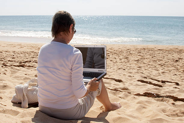 istock Woman with laptop on beach 172298300