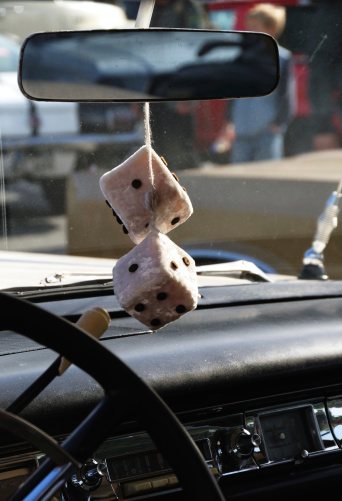 fuzzy dice on the mirror of an american muscle car. ready to race