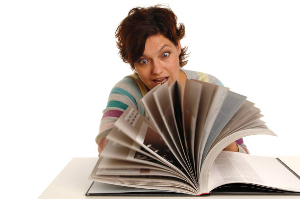 istock Young woman browsing and looking in a book 172298751