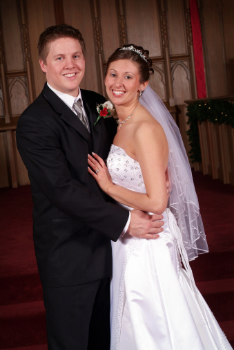 Beautiful young newlyweds smiling to the camera shortly after getting married.