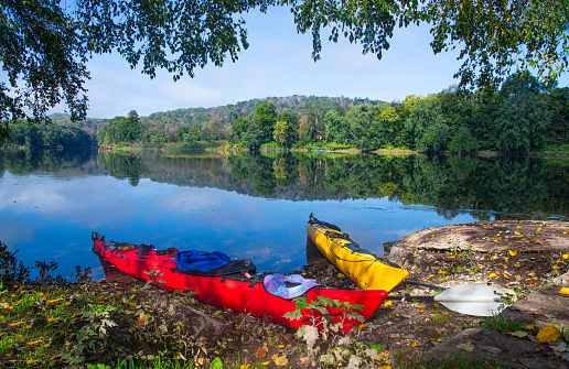 Horizontal photo of a colorful red and yellow kayak on the banks of the Delaware River in Worthington State Forest, New Jersey