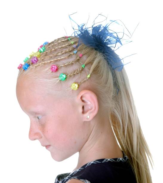 Professional hairstylist artfully braiding brown hair with intricate patterns and applying subtle hair rings during a beauty treatment, reflecting modern hair fashion and styling