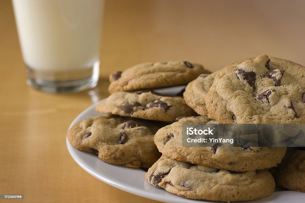 Galletas con pedacitos de Chocolate y de placa de vaso de leche en la tabla - Foto de stock de Al horno libre de derechos