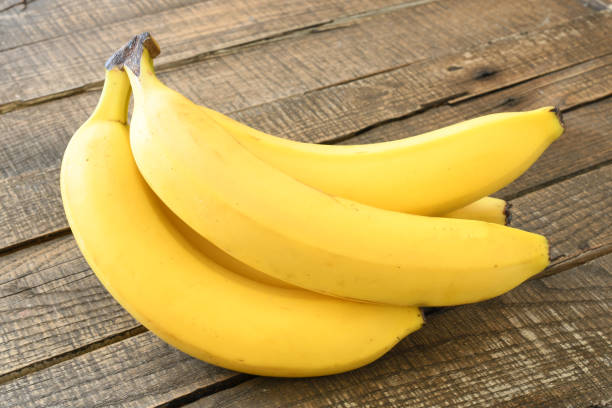 istock Fresh bananas on wooden background 1723008662