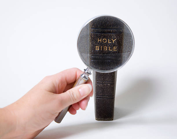 увеличительное стекло и библия - investigative стоковые фото и изображения