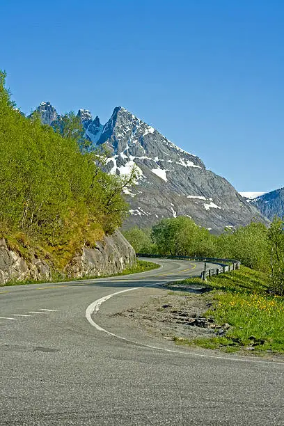 A road in the countryside in the north of Norway. Great scenery with snow-covered mountains one moment and beatiful beaches the next.