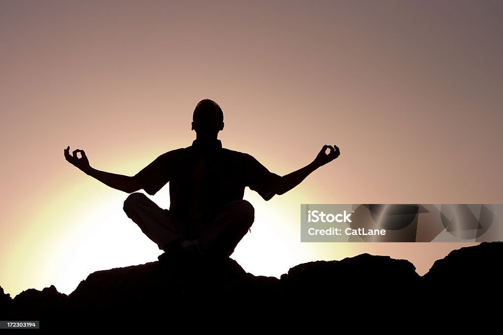 Meditation through Yoga Man meditating on a mountain top in Utah Adult Stock Photo
