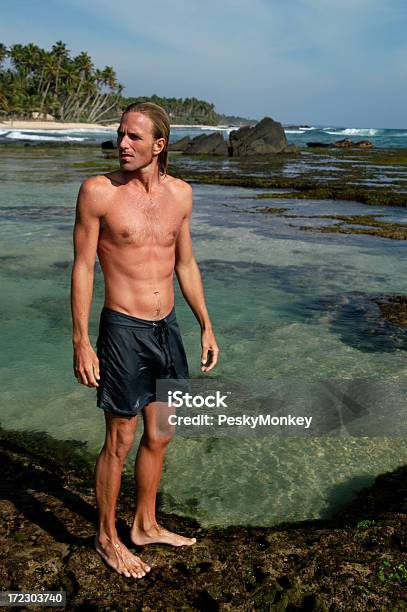 Guy In Shorts Steht Neben Tropischen Lagune Stockfoto und mehr Bilder von Abgeschiedenheit - Abgeschiedenheit, Athlet, Badebekleidung