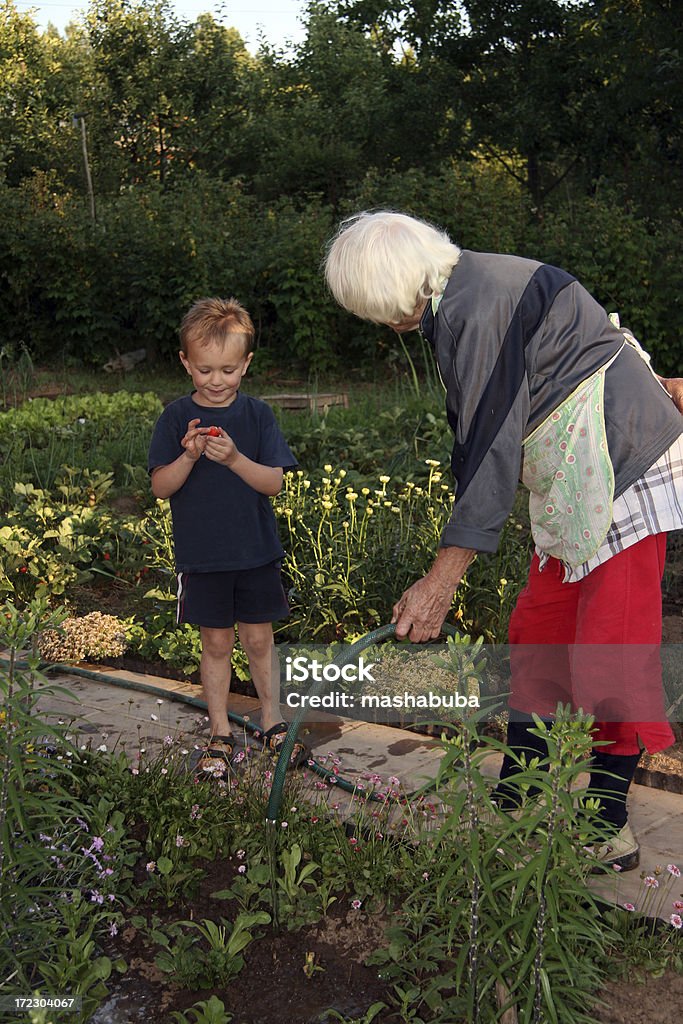 Nonna e nipote su giardino - Foto stock royalty-free di Abbracciare una persona