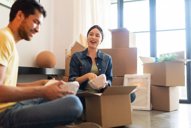 istock Young couple talking while unpacking moving boxes at the new home 1723047848