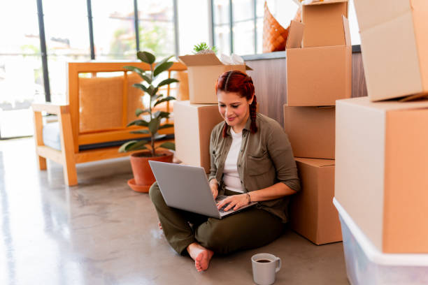 istock Mid adult woman using computer at the new house 1723048382