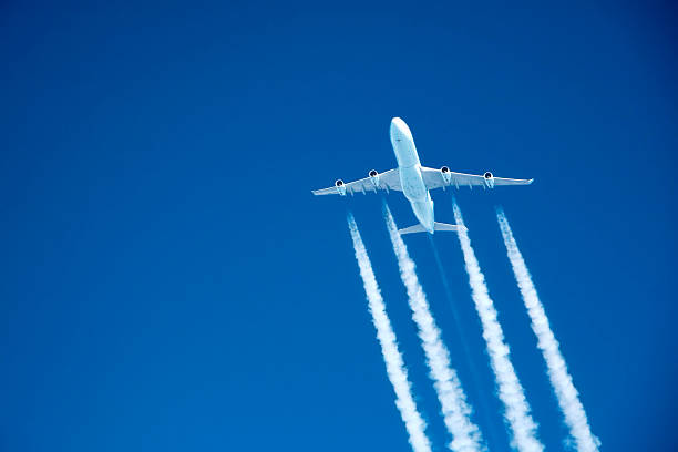 flying high. Commercial jet at altitude contrails streaming from a jumbo jet on blue sky at altitude vapor trail photos stock pictures, royalty-free photos & images