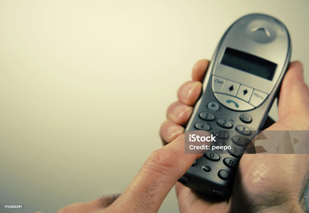 wireless phone series cross processed image of caucasian male hand holding a cordless phone with plenty of copy space with very little depth of field Adult Stock Photo