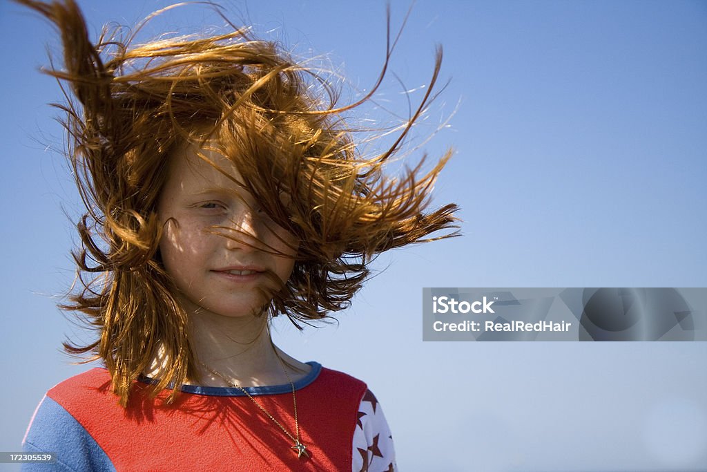 Red haired girl in the wind Girl with mobile phone Wind Stock Photo