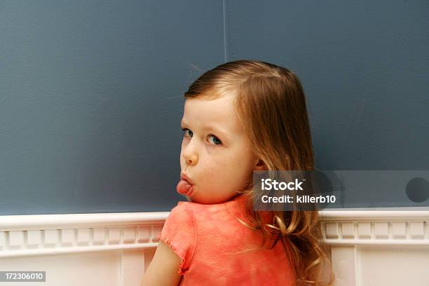 Girl Standing In Corner With Tongue Stuck Out For Time Out Stock Photo - Download Image Now