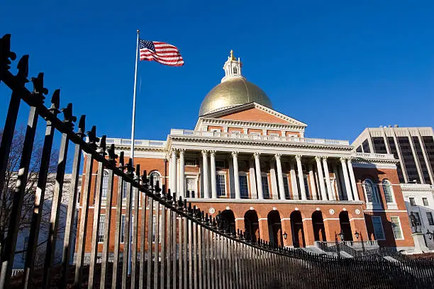 "Massachusetts State House and Capital, USA. Late afternoon light, deep blue sky and angled view of black iron fence, gold dome shining, American flagPlease see some similar pictures from my portfolio:"