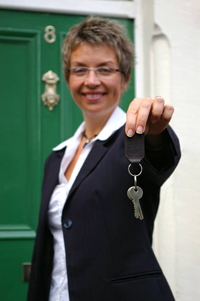 Young business woman handing over the keys to a property stock photo