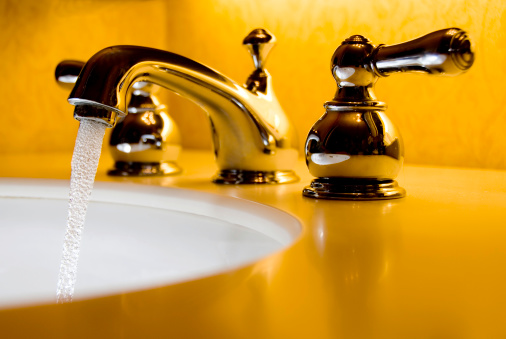 A narrow depth of field image of a very high end faucet, sink, and counter.