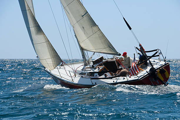 Sailing regatta in the Gulf of Finland at sunset, two sailing yachts competing in a race, splashing water from under the boats, teamwork, board the boat. High quality photo