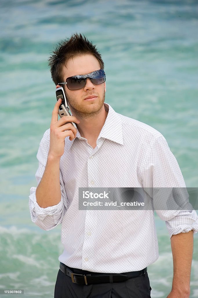 Uomo d'affari con telefono cellulare con vista oceano - Foto stock royalty-free di Abbigliamento