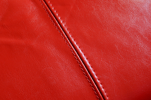 red leather background with stitching.